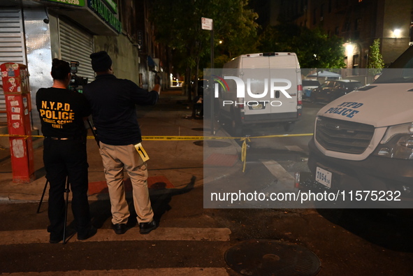 Investigators from the NYPD Crime Scene Unit investigate and place evidence markers and take photographs of the scene. One man is dead and a...