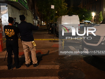 Investigators from the NYPD Crime Scene Unit investigate and place evidence markers and take photographs of the scene. One man is dead and a...