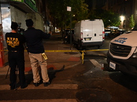 Investigators from the NYPD Crime Scene Unit investigate and place evidence markers and take photographs of the scene. One man is dead and a...