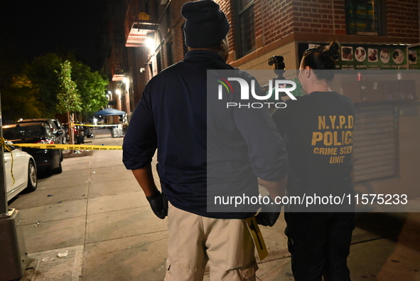 Investigators from the NYPD Crime Scene Unit investigate and place evidence markers and take photographs of the scene. One man is dead and a...