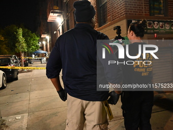 Investigators from the NYPD Crime Scene Unit investigate and place evidence markers and take photographs of the scene. One man is dead and a...