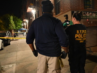 Investigators from the NYPD Crime Scene Unit investigate and place evidence markers and take photographs of the scene. One man is dead and a...