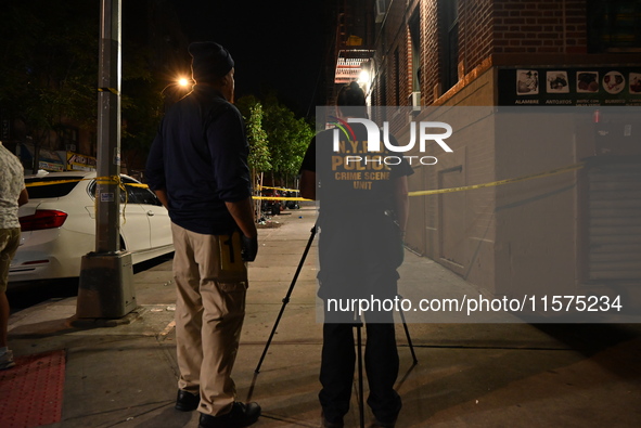 Investigators from the NYPD Crime Scene Unit investigate and place evidence markers and take photographs of the scene. One man is dead and a...