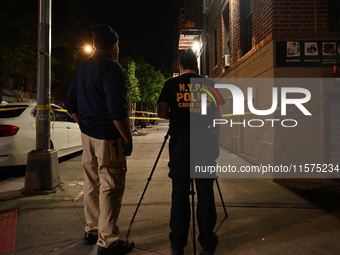 Investigators from the NYPD Crime Scene Unit investigate and place evidence markers and take photographs of the scene. One man is dead and a...