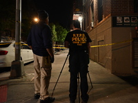 Investigators from the NYPD Crime Scene Unit investigate and place evidence markers and take photographs of the scene. One man is dead and a...