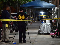 Investigators from the NYPD Crime Scene Unit investigate and place evidence markers and take photographs of the scene. One man is dead and a...