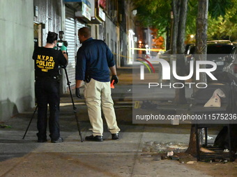 Investigators from the NYPD Crime Scene Unit investigate and place evidence markers and take photographs of the scene. One man is dead and a...