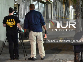 Investigators from the NYPD Crime Scene Unit investigate and place evidence markers and take photographs of the scene. One man is dead and a...