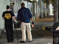 Investigators from the NYPD Crime Scene Unit investigate and place evidence markers and take photographs of the scene. One man is dead and a...