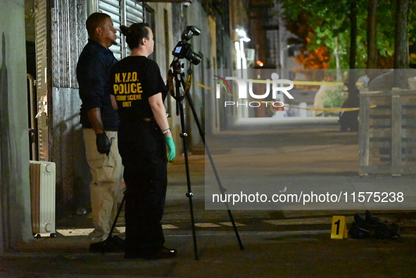 Investigators from the NYPD Crime Scene Unit investigate and place evidence markers and take photographs of the scene. One man is dead and a...