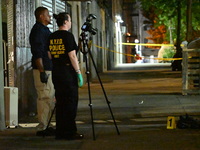 Investigators from the NYPD Crime Scene Unit investigate and place evidence markers and take photographs of the scene. One man is dead and a...