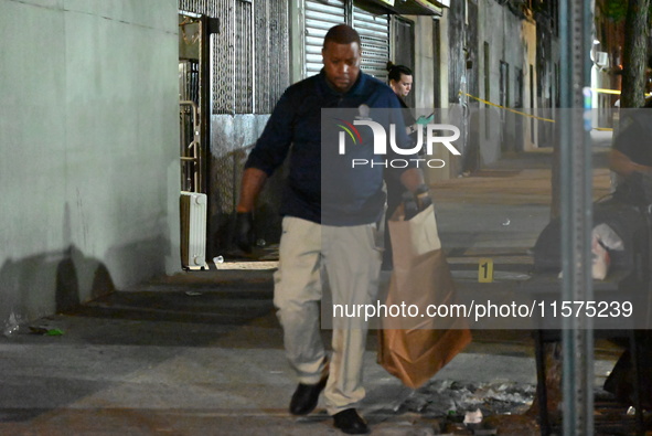 Investigators from the NYPD Crime Scene Unit investigate and place evidence markers and take photographs of the scene. One man is dead and a...