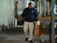 Investigators from the NYPD Crime Scene Unit investigate and place evidence markers and take photographs of the scene. One man is dead and a...