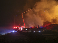 Fire crews work to put out a fire at a wood processing plant in Duzhuang village, Wan'an Town, Xinjiang County, Yuncheng City, North China's...