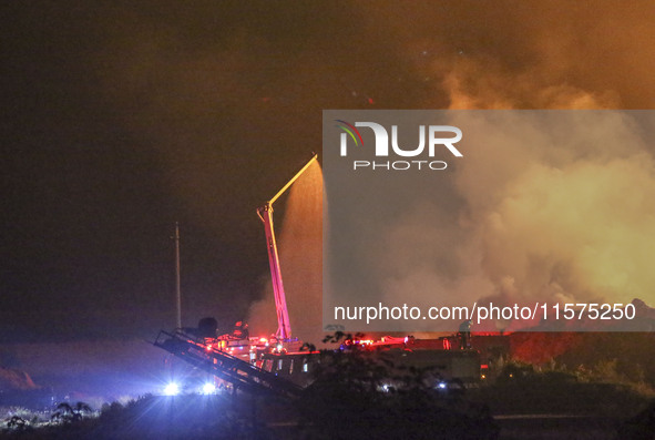 Fire crews work to put out a fire at a wood processing plant in Duzhuang village, Wan'an Town, Xinjiang County, Yuncheng City, North China's...