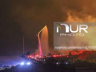 Fire crews work to put out a fire at a wood processing plant in Duzhuang village, Wan'an Town, Xinjiang County, Yuncheng City, North China's...