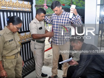 A police officer checks aspirants as they enter an examination hall to appear in the Assam Direct Recruitment Exam 2024 (ADRE) for filling u...