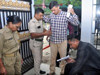 A police officer checks aspirants as they enter an examination hall to appear in the Assam Direct Recruitment Exam 2024 (ADRE) for filling u...