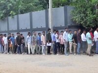 Candidates stand in a queue before appearing in a written examination for vacant Group III posts in the Assam government in Guwahati, India,...