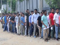 Candidates stand in a queue before appearing in a written examination for vacant Group III posts in the Assam government in Guwahati, India,...