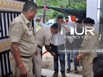 A police officer checks aspirants as they enter an examination hall to appear in the Assam Direct Recruitment Exam 2024 (ADRE) for filling u...