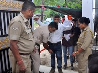 A police officer checks aspirants as they enter an examination hall to appear in the Assam Direct Recruitment Exam 2024 (ADRE) for filling u...