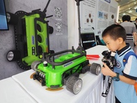 A child visits a ''negative pressure adsorption wall climbing robot'' during the 14th Beijing Science Carnival in Beijing, China, on Septemb...