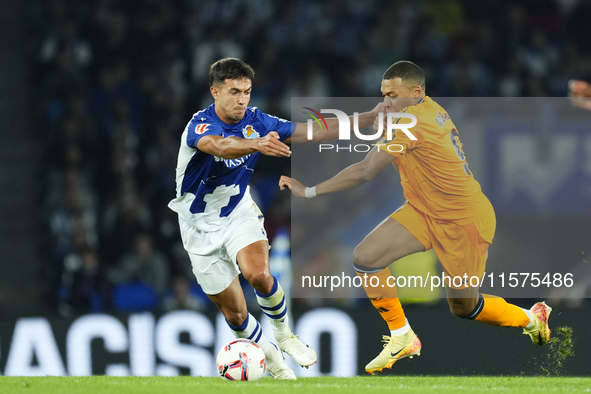 Kylian Mbappe centre-forward of Real Madrid and France and Martin Zubimendi defensive midfield of Real Sociedad and Spain compete for the ba...