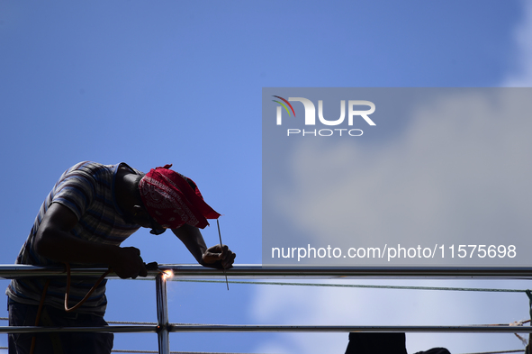 A worker welds an aluminum bar in Kirtipur, Kathmandu, Nepal, on September 15, 2024. He earns a monthly income of NRs. 15,000 (US$ 150) 