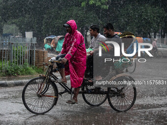 A rickshaw puller wears a raincoat as rain continues in Dhaka, Bangladesh, on September 15, 2024. (