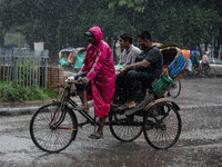 A rickshaw puller wears a raincoat as rain continues in Dhaka, Bangladesh, on September 15, 2024. (