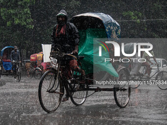 A rickshaw puller wears a raincoat as rain continues in Dhaka, Bangladesh, on September 15, 2024. (