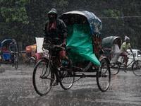 A rickshaw puller wears a raincoat as rain continues in Dhaka, Bangladesh, on September 15, 2024. (