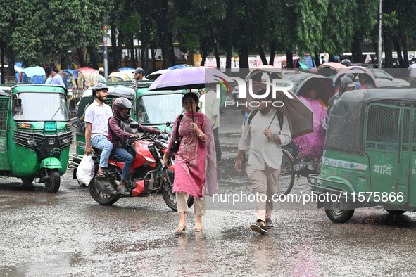 A person with an umbrella makes their way along a street during heavy rainfall in Dhaka, Bangladesh, on September 15, 2024. 