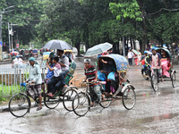 A rickshaw puller with a passenger makes his way along a street during heavy rainfall in Dhaka, Bangladesh, on September 15, 2024. (