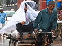 A rickshaw puller with a passenger makes his way along a street during heavy rainfall in Dhaka, Bangladesh, on September 15, 2024. (