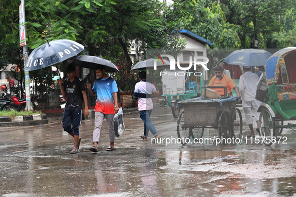 A person with an umbrella makes their way along a street during heavy rainfall in Dhaka, Bangladesh, on September 15, 2024. 