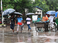 A person with an umbrella makes their way along a street during heavy rainfall in Dhaka, Bangladesh, on September 15, 2024. (