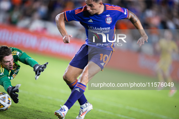 Real Salt Lake goalkeeper Gavin Beavers (35) attempts to block a shot from Houston Dynamo forward Ezequiel Ponce (10) but misses the ball, r...