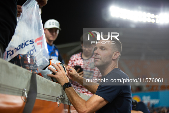 Houston Dynamo coach Ben Olsen signs a soccer ball for young fans after a match between Houston Dynamo and Real Salt Lake at Shell Energy St...