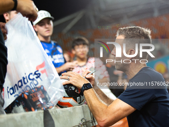 Houston Dynamo coach Ben Olsen signs a soccer ball for young fans after a match between Houston Dynamo and Real Salt Lake at Shell Energy St...