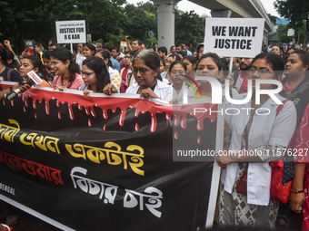 Medical workers march along a street during a protest condemning the rape and murder of a trainee medic at a government-run hospital in Kolk...