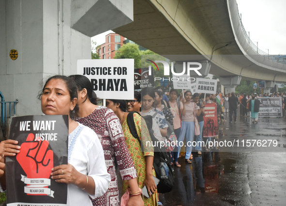 Women march along a street during a protest condemning the rape and murder of a trainee medic at a government-run hospital in Kolkata, India...