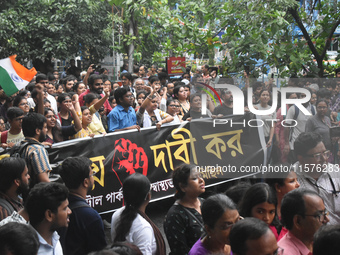 Medics march along a street during a protest condemning the rape and murder of a trainee medic at a government-run hospital in Kolkata, Indi...