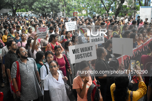 Doctors, medical workers, and citizens march along a street during a protest condemning the rape and murder of a trainee medic at a governme...