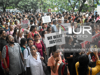 Doctors, medical workers, and citizens march along a street during a protest condemning the rape and murder of a trainee medic at a governme...