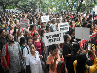 Doctors, medical workers, and citizens march along a street during a protest condemning the rape and murder of a trainee medic at a governme...