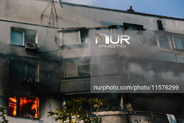 A man in a fire trap waits for rescuers to help him from the roof, in Kharkiv, Ukraine, on September 15, 2024. 