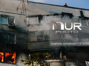 A man in a fire trap waits for rescuers to help him from the roof, in Kharkiv, Ukraine, on September 15, 2024. (