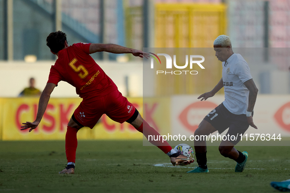 In Ta' Qali, Malta, on September 14, 2024, Alex Bruno de Souza Silva (R) of Hibernians competes for the ball with Augustin Sandona (L) of Bi...